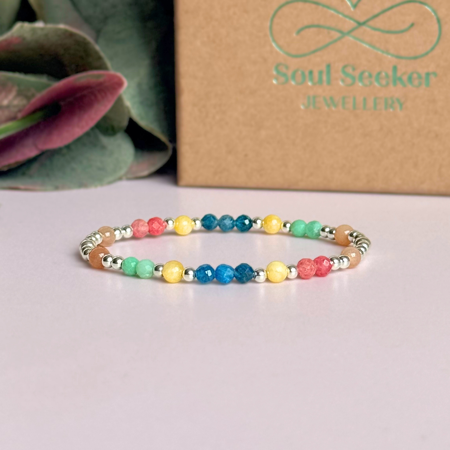 'Key West' sterling silver dainty beaded bracelet with apatite, rhodochrosite, yellow calcite, chrysoprase and peach moonstone. Made with round 3mm sterling silver beads and 4mm smooth and faceted round crystal gemstone beads. Pictured in front of the gift box