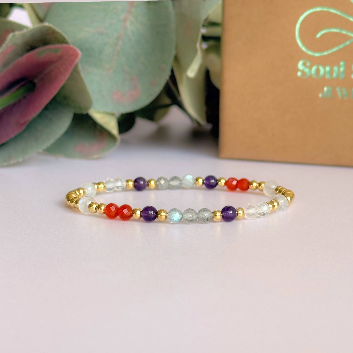 Dainty gold vermeil crystal bracelet featuring five crystals, in 4mm faceted and smooth round style, each believed to help with hormonal balance. Featuring amethyst, moonstone, carnelian, labradorite and rose quartz. Pictured in front of the gift box.