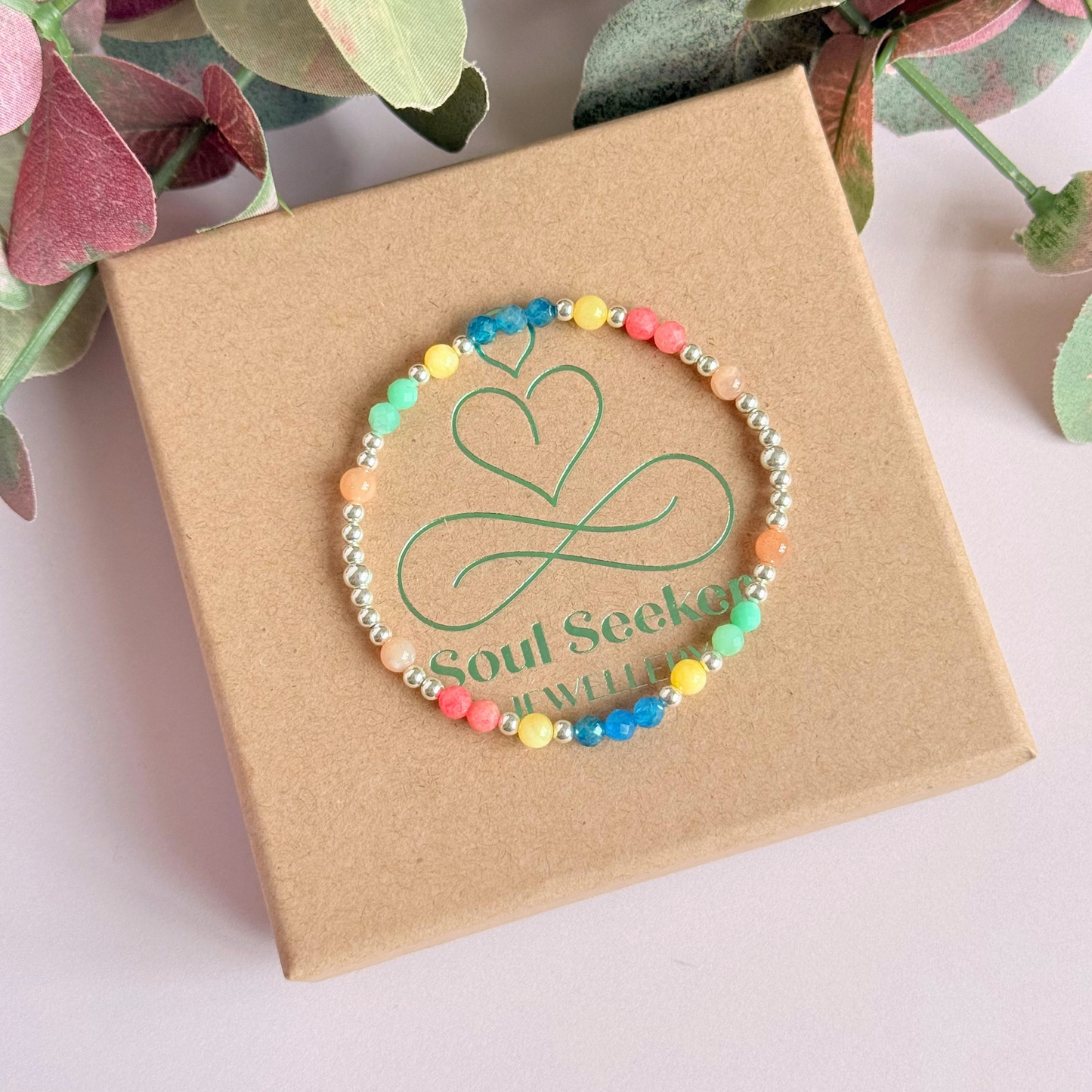 'Key West' sterling silver dainty beaded bracelet with apatite, rhodochrosite, yellow calcite, chrysoprase and peach moonstone. Made with round 3mm sterling silver beads and 4mm smooth and faceted round crystal gemstone beads. Pictured from above, on top of the gift box