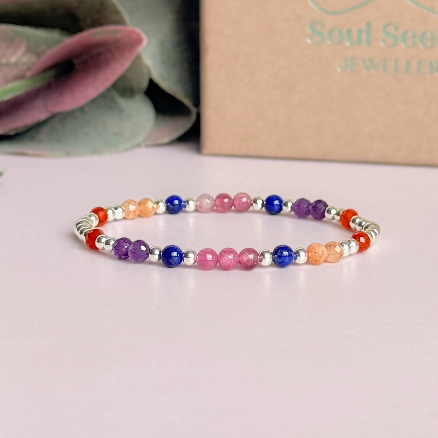 ‘Arabian Sunset' sterling silver dainty beaded bracelet with pink tourmaline, sunstone, carnelian, lapis lazuli and amethyst. Made with round 3mm sterling silver beads and 4mm smooth and faceted round crystal gemstone beads. Pictured in front of the gift box