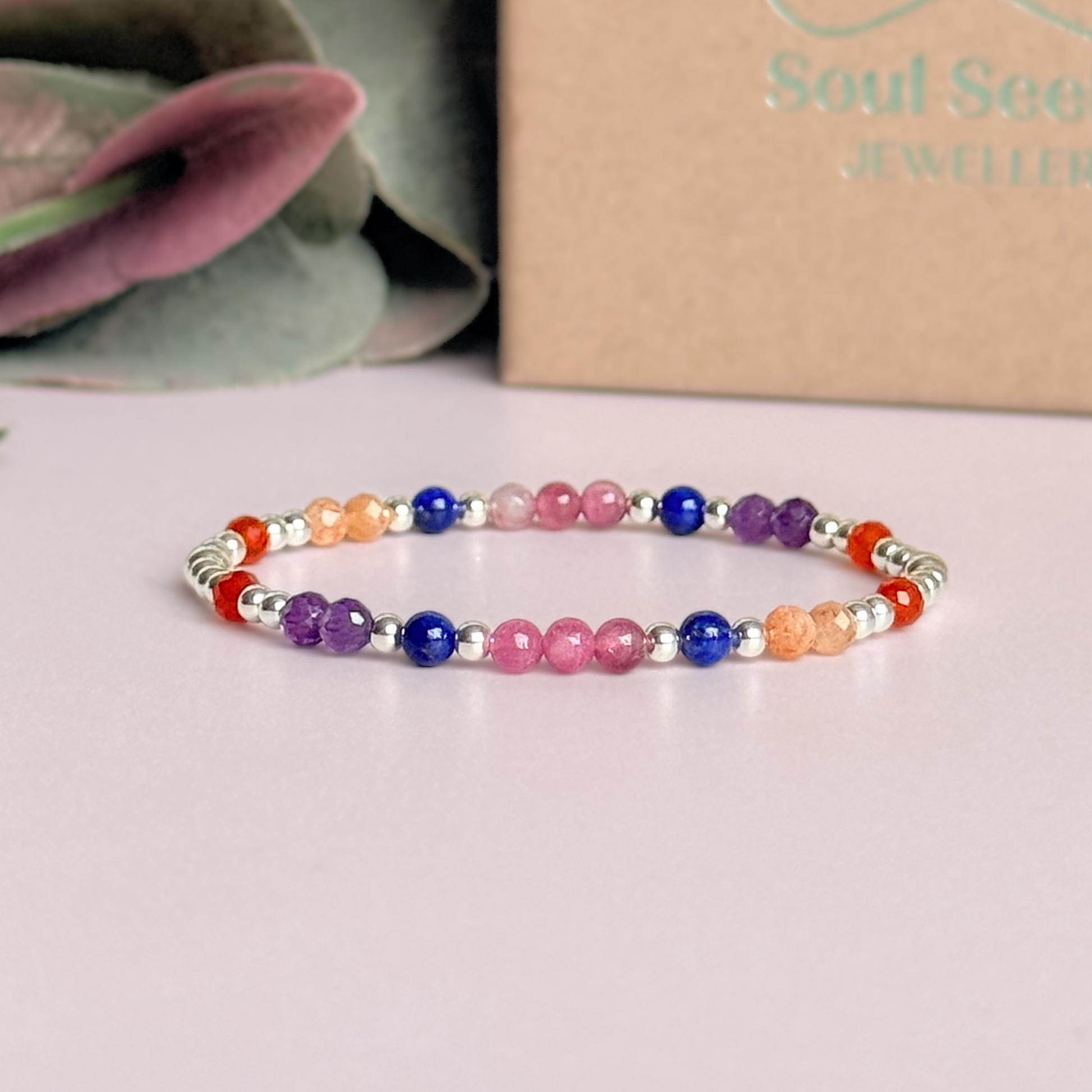 ‘Arabian Sunset' sterling silver dainty beaded bracelet with pink tourmaline, sunstone, carnelian, lapis lazuli and amethyst. Made with round 3mm sterling silver beads and 4mm smooth and faceted round crystal gemstone beads. Pictured in front of the gift box