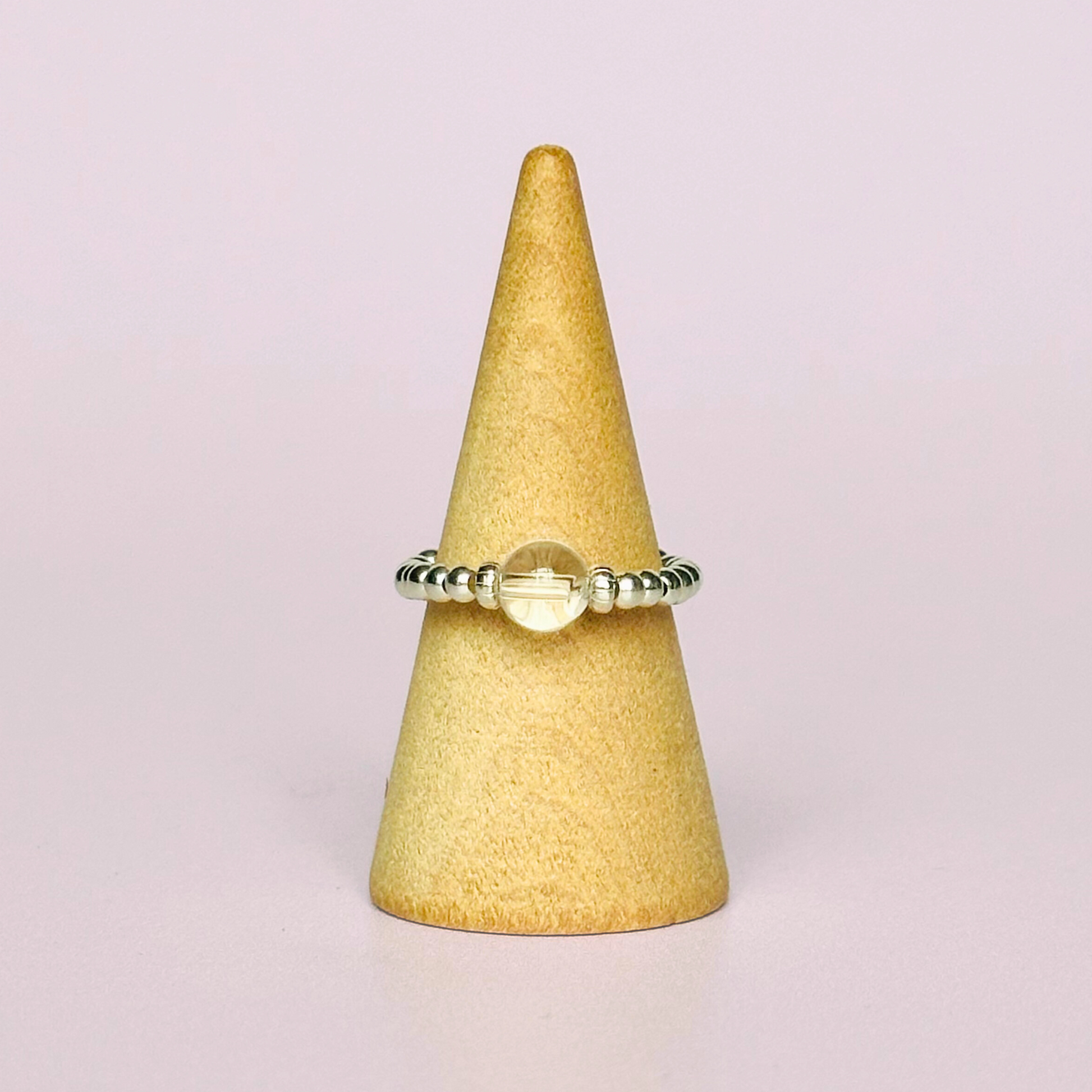 This sterling silver clear quartz ring features a 6mm round ethically sourced clear quartz bead, surrounded by sterling silver corrugated rondelle beads and delicate 2.5mm sterling silver beads. April birthstone.
