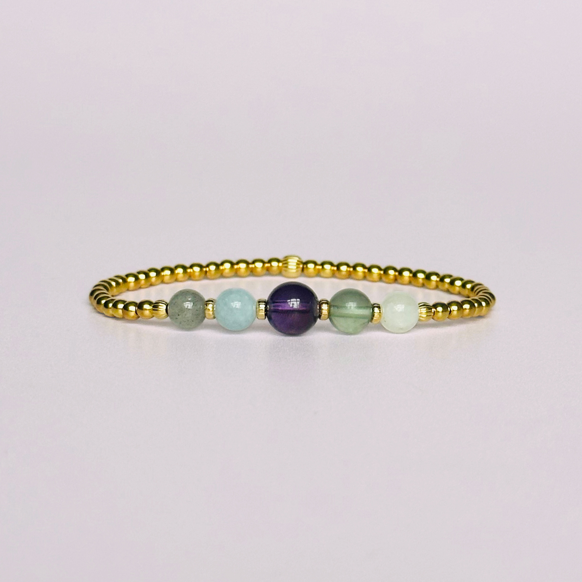 This gold vermeil Aquarius bracelet is made with a selection of five healing crystals all believed to resonate with the Aquarius zodiac sign. The central bead is 8mm, the other four are 6mm. On an elasticated band of 3mm gold vermeil beads with corrugated accent beads. Featuring labradorite, moonstone, fluorite, amethyst and aquamarine.