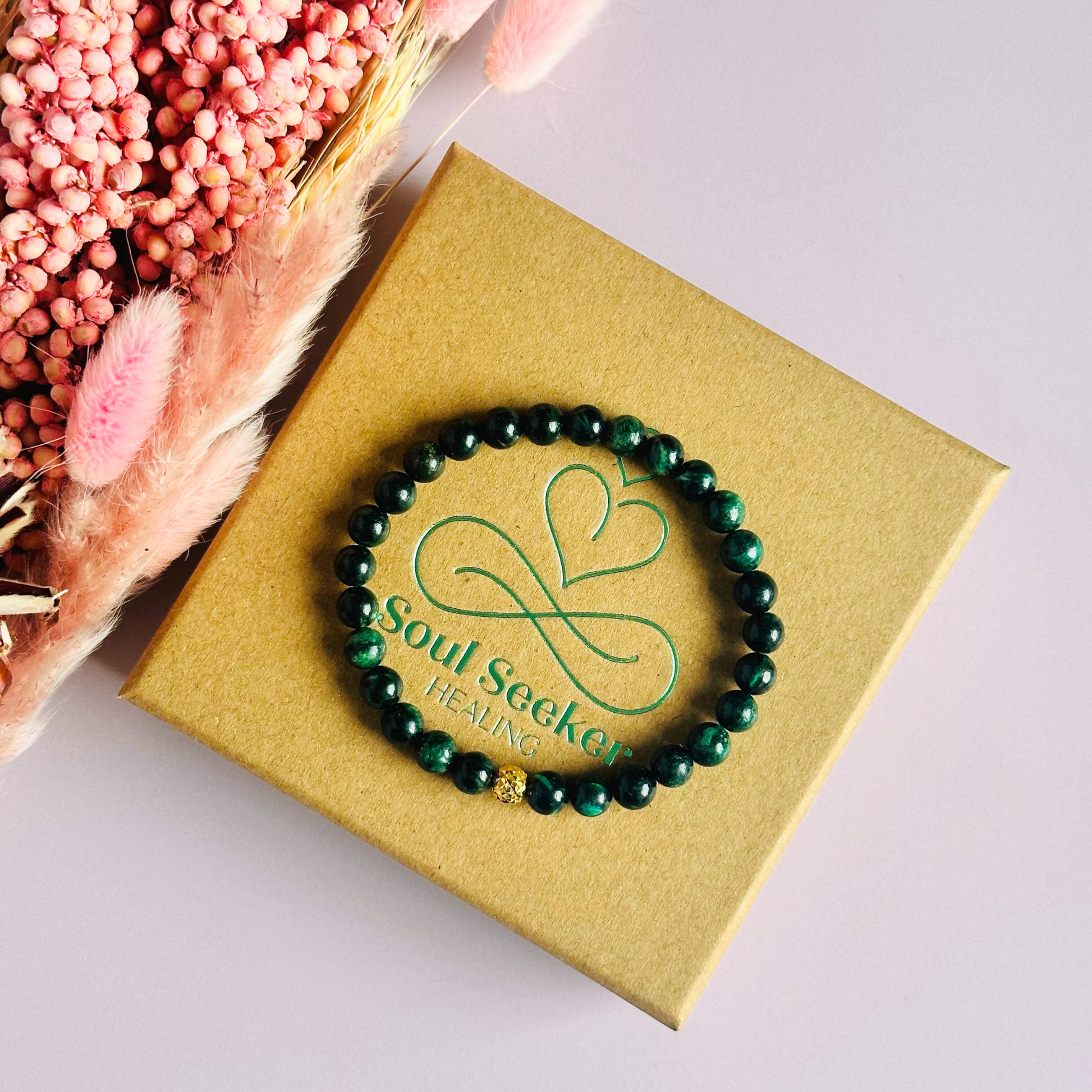 Crystal healing bracelet featuring a band of 6mm, dark Emerald genuine round beads with one 6mm faceted bead as a focal point, in either sterling silver or gold vermeil. Elasticated for comfort