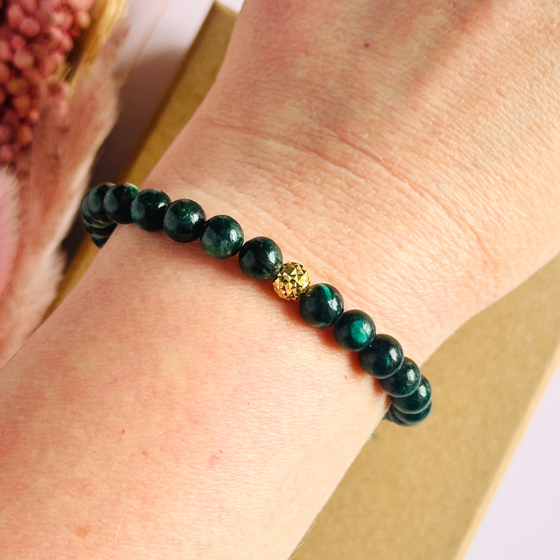 Crystal healing bracelet featuring a band of 6mm, dark Emerald genuine round beads with one 6mm faceted bead as a focal point, in either sterling silver or gold vermeil. Elasticated for comfort