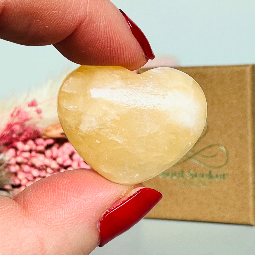 A beautiful ethically mined yellow calcite heart, presented on an eco-friendly textured card with the words 'A stone of joy and confidence.' This heart shaped crystal measures approximately 25mm x 25mm.