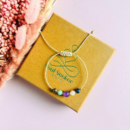 Eco-friendly, waxed cotton cord crystal healing bracelet featuring five crystals each believed to help deal with anxiety. Includes pyrite, amazonite, amethyst, rose quartz and sodalite. Adjustable as it fastens with a sliding macramé clasp. Choose from either sterling silver, gold vermeil or rose gold vermeil accent beads.
