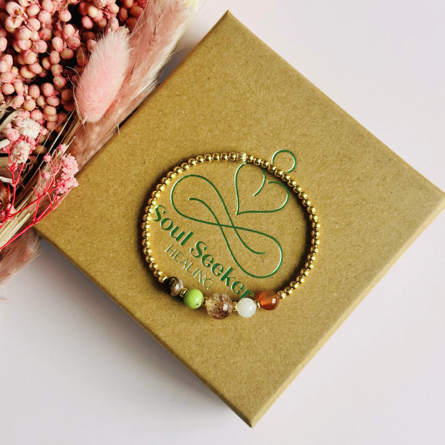 This gold vermeil Cancer bracelet is made with a selection of five healing crystals all believed to resonate with the Cancer zodiac sign. The central bead is 8mm, the other four are 6mm. On an elasticated band of 3mm gold vermeil beads with corrugated accent beads. Featuring chrysoprase, rhodonite, sunstone, moonstone and carnelian.