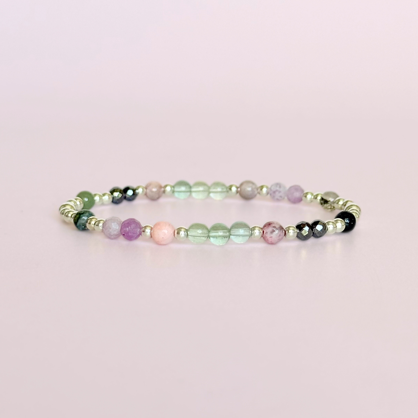 Dainty crystal bracelet featuring five crystals all believed to help with focus, clarity and overwhelm. Featuring fluorite, hematite, lepidolite, moss agate and pink zebra jasper. Featuring 3mm sterling silver round beads and 4mm faceted round and smooth round crystal beads. Photo of the bracelet on its own.