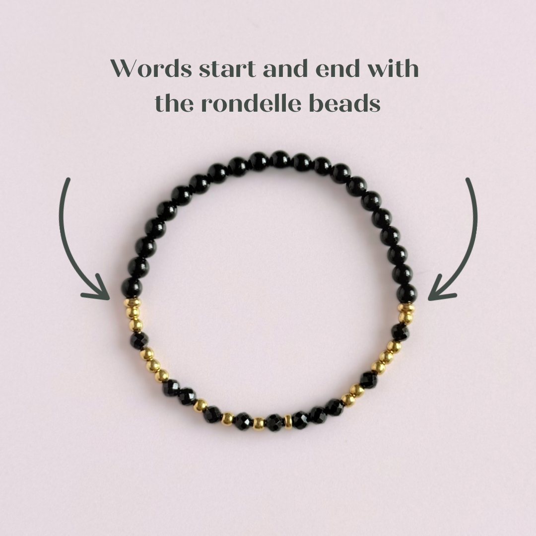 Elasticated black tourmaline crystal morse code bracelet spells out the words ‘Fuck off’ in a combination of 4mm round black tourmaline beads, 4mm faceted black tourmaline beads and either sterling silver or gold vermeil 3mm round beads. The words start and end at the rondelle spacer beads. Picture shows gold bracelet from above, showing ehere the morse code element starts and ends