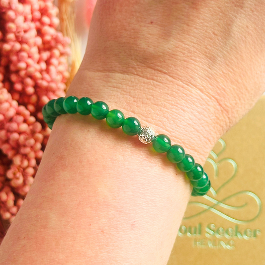Green agate crystal healing bracelet made with 6mm smooth, round green agate beads and your choice of sterling silver or gold vermeil 6mm faceted focal bead. Elasticated for comfort.