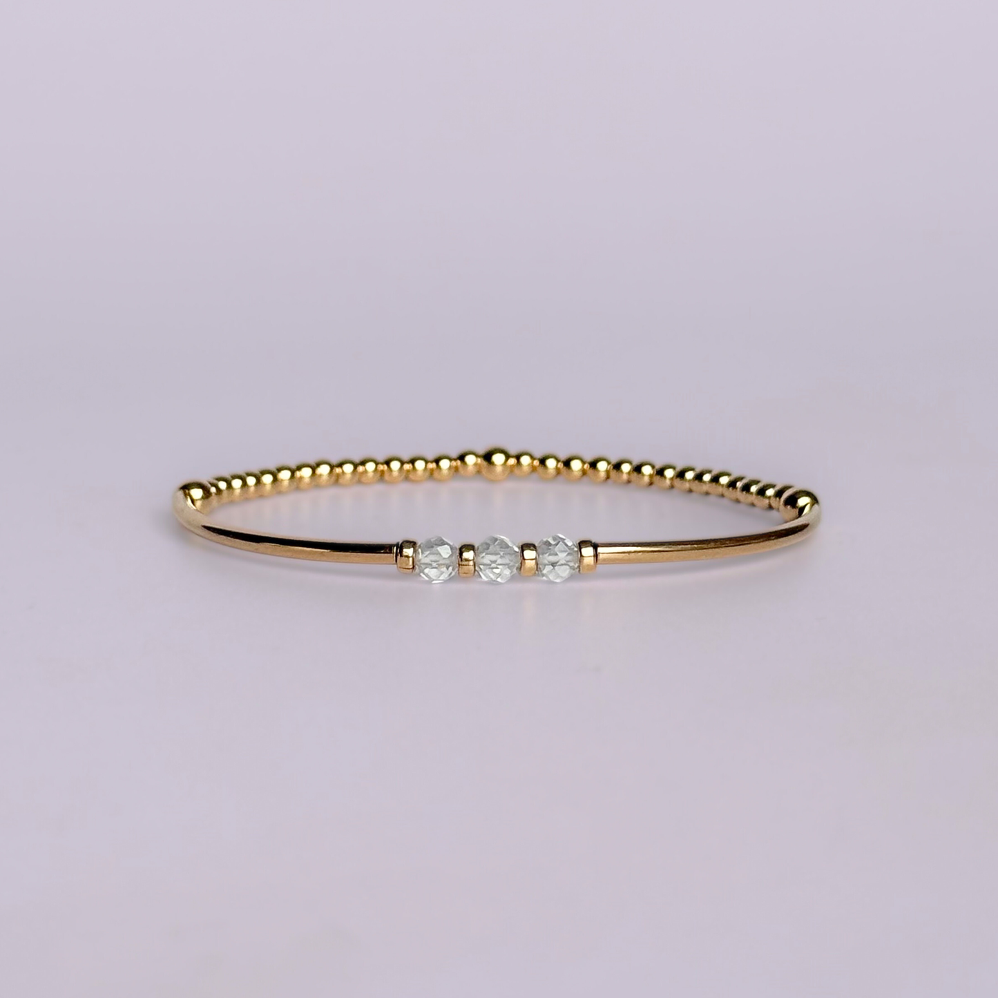 Gold filled elasticated stretch bracelet featuring five faceted clear quartz 4mm crystal beads, one to celebrate each decade for a 30th birthday present. April birthstone bracelet with gold filled tube beads and 3mm spacer beads.