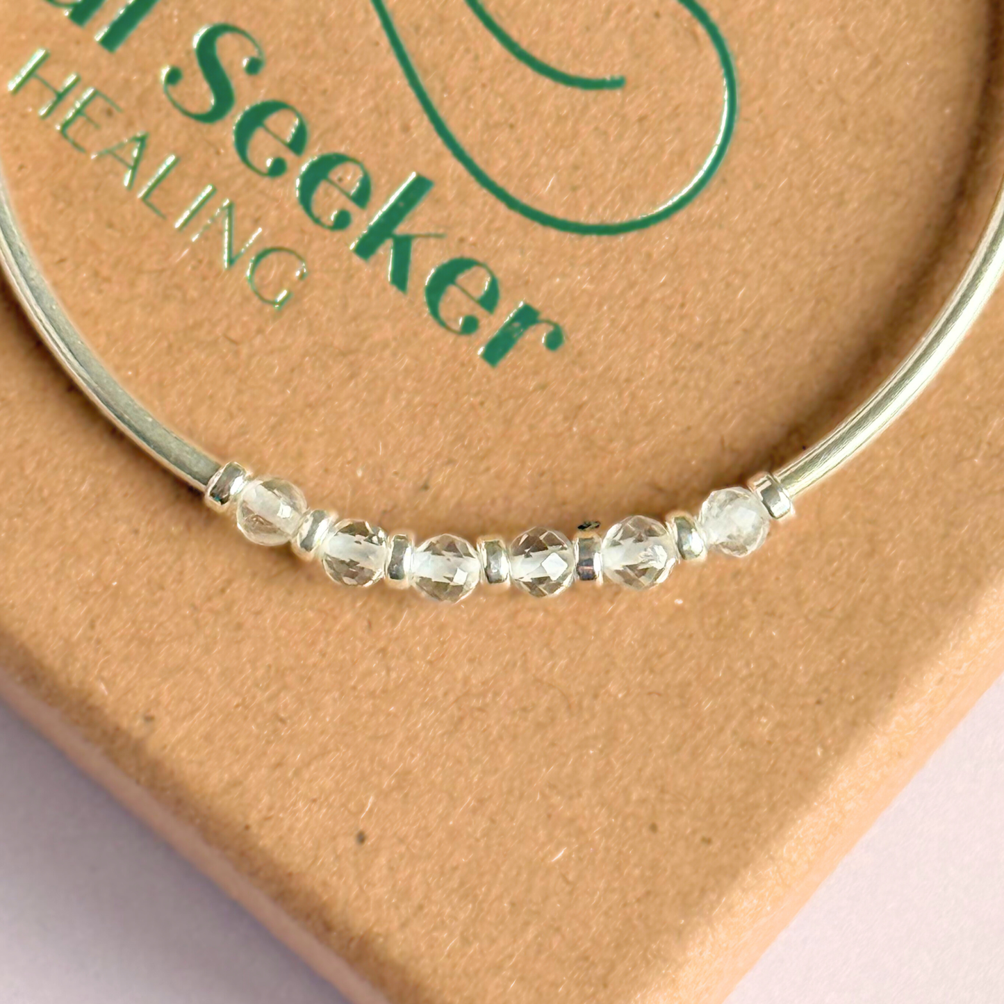 Sterling silver elasticated stretch bracelet featuring six clear quartz crystal beads, one to celebrate each decade for a 60th birthday present. With sterling silver tube beads and 3mm spacer beads.