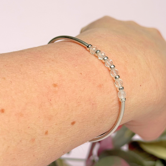 Sterling silver elasticated stretch bracelet featuring six clear quartz crystal beads, one to celebrate each decade for a 60th birthday present. With sterling silver tube beads and 3mm spacer beads.