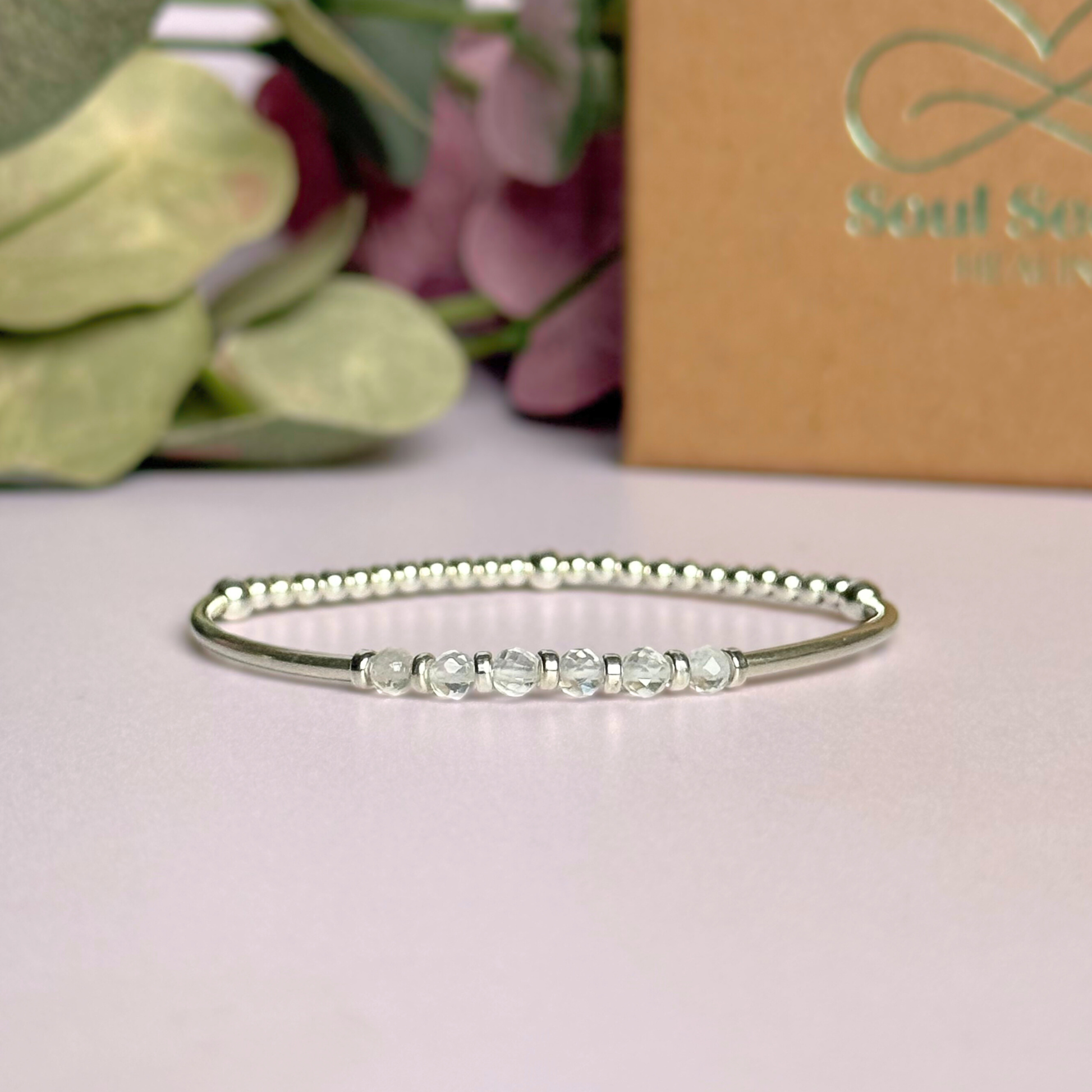 Sterling silver elasticated stretch bracelet featuring six clear quartz crystal beads, one to celebrate each decade for a 60th birthday present. With sterling silver tube beads and 3mm spacer beads.