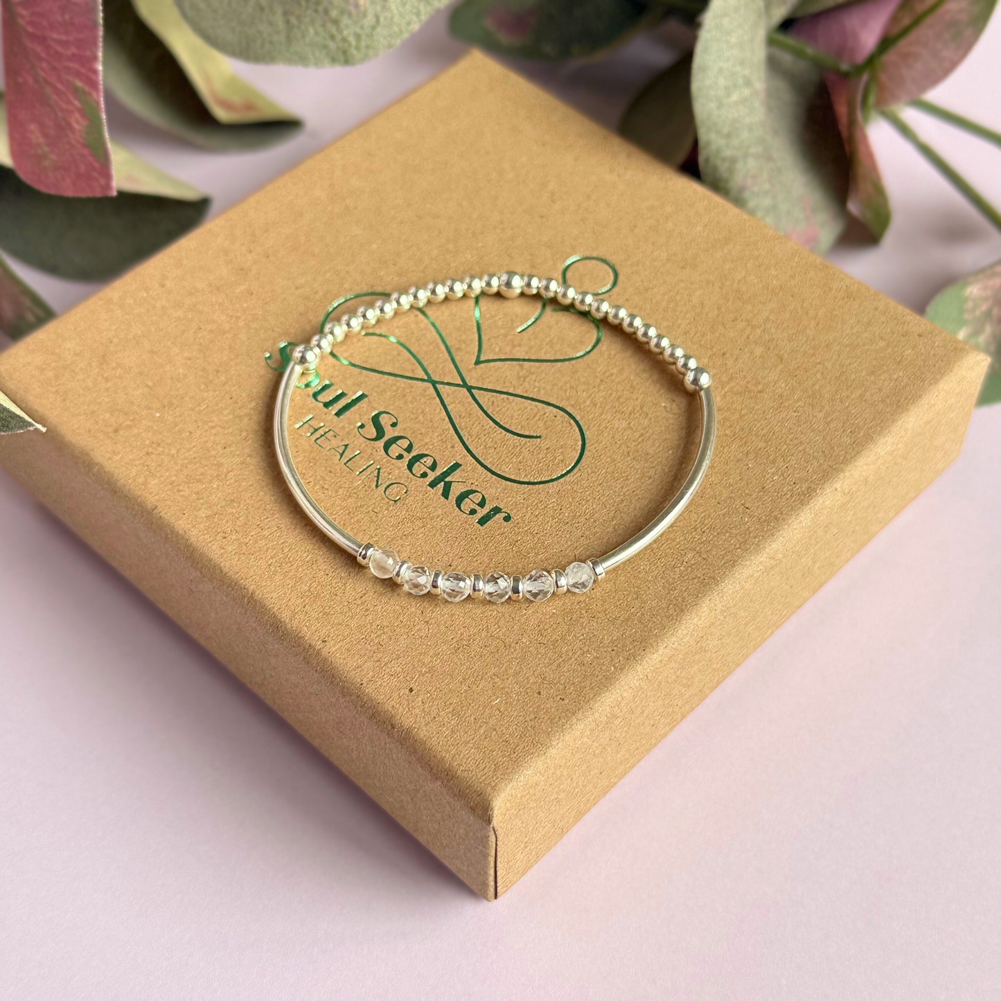 Sterling silver elasticated stretch bracelet featuring six clear quartz crystal beads, one to celebrate each decade for a 60th birthday present. With sterling silver tube beads and 3mm spacer beads.