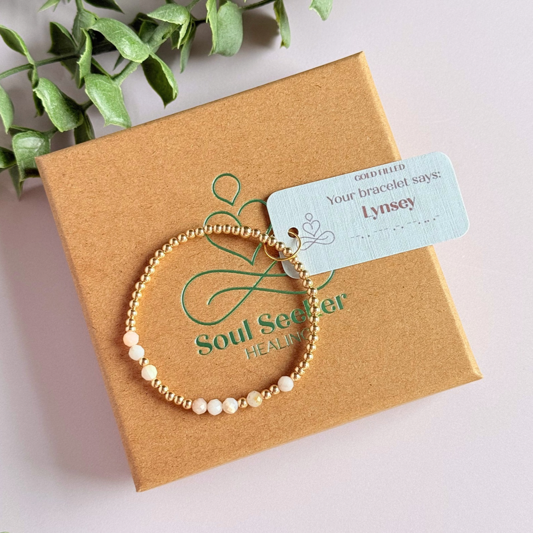 Morse code secret message bracelet spelling out your chosen name in gold filled and pink opal crystal beads. Elasticated with 4mm faceted pink opal beads and 3mm gold filled beads. Custom October birthstone bracelet.
