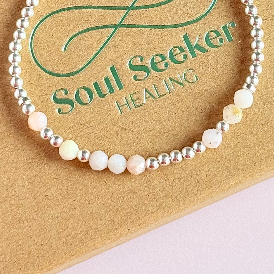 Morse code secret message bracelet spelling out your chosen name in sterling silver and pink opal crystal beads. Elasticated with 4mm faceted pink opal beads and 3mm sterling silver beads. Custom October birthstone bracelet.