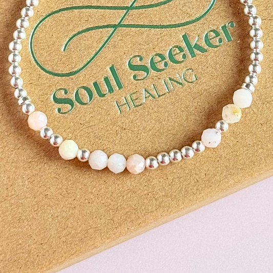 Morse code secret message bracelet spelling out your chosen name in sterling silver and pink opal crystal beads. Elasticated with 4mm faceted pink opal beads and 3mm sterling silver beads. Custom October birthstone bracelet.