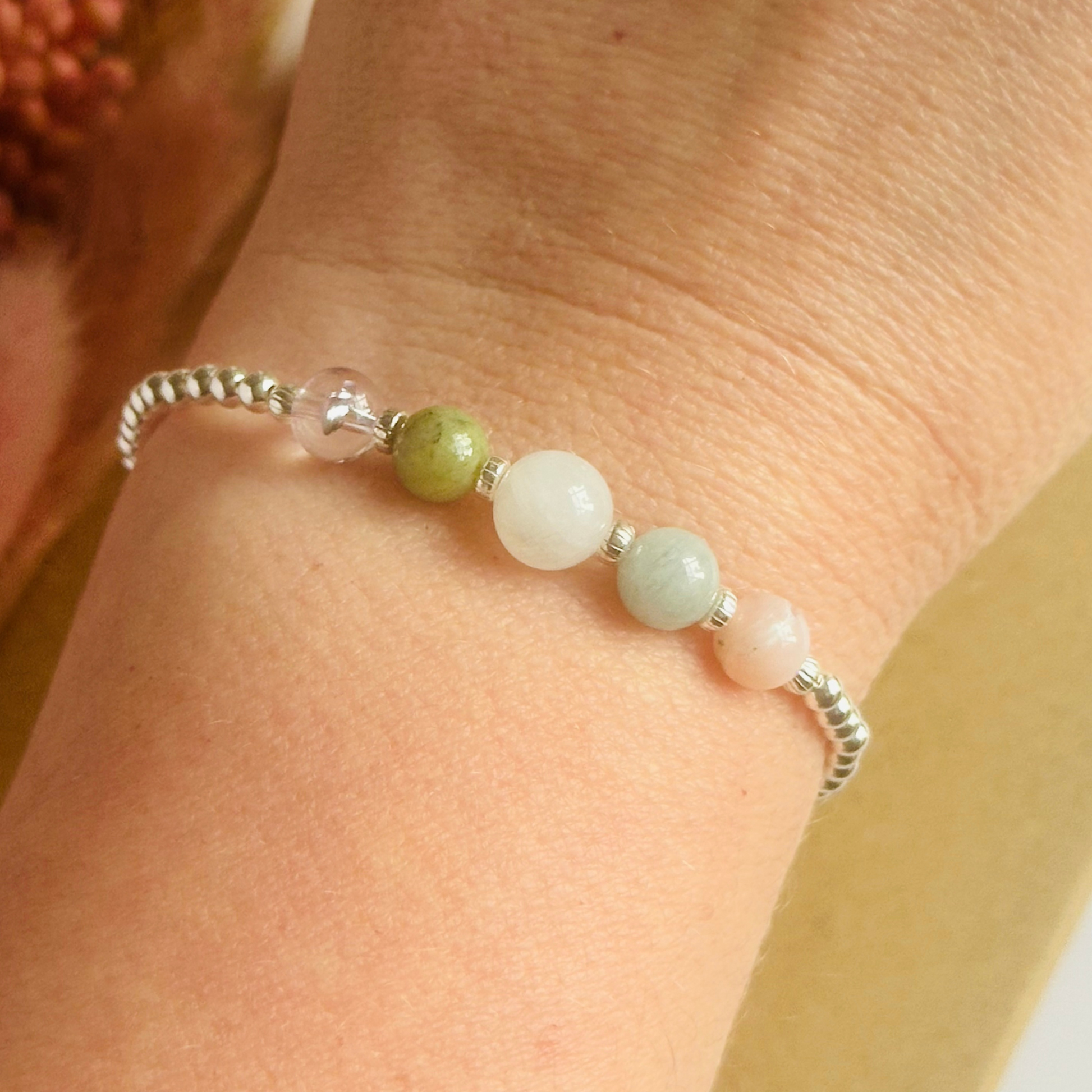 This sterling silver Libra bracelet is made with a selection of five healing crystals all believed to resonate with the Libra zodiac sign. The central bead is 8mm, the other four are 6mm. On an elasticated band of 3mm sterling silver beads with corrugated accent beads. Featuring ametrine, jade, moonstone, aquamarine and pink opal.