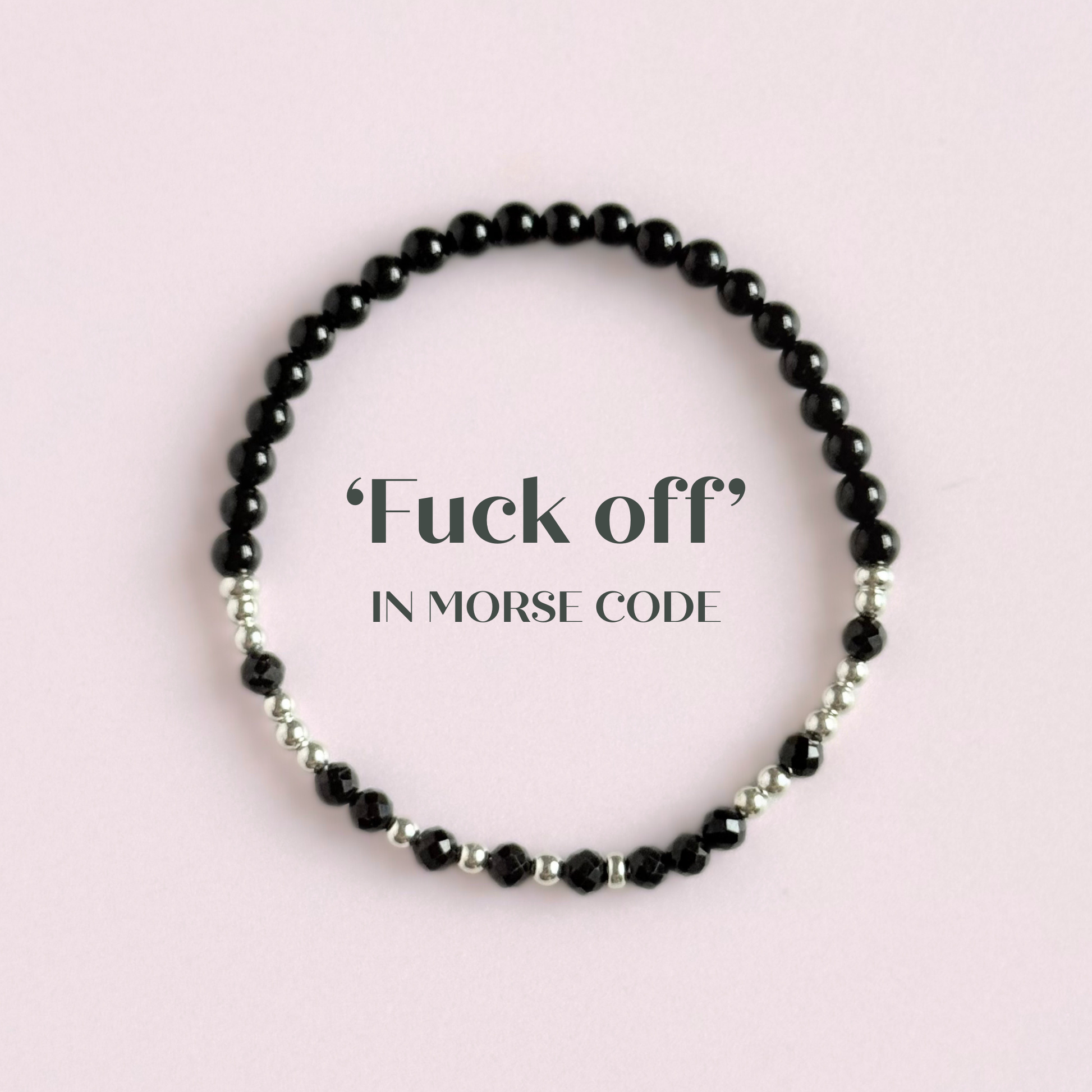 Elasticated black tourmaline crystal morse code bracelet spells out the words ‘Fuck off’ in a combination of 4mm round black tourmaline beads, 4mm faceted black tourmaline beads and either sterling silver or gold vermeil 3mm round beads. The words start and end at the rondelle spacer beads. Picture shows bracelet in silver, from above, with the words fuck off.