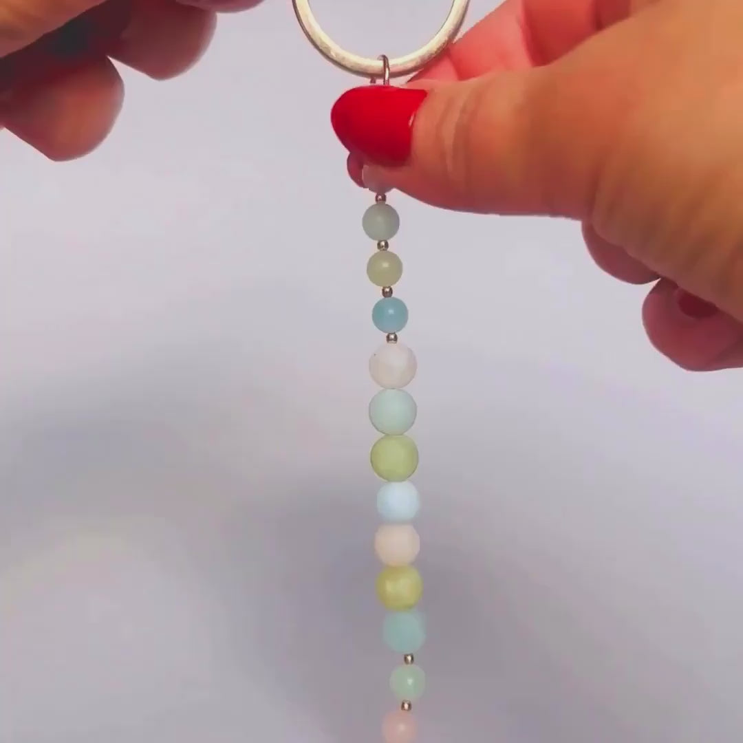 Frosted morganite breath work beads on a rose gold keychain/bag charm. For the 4-7-8 counted breathing method.