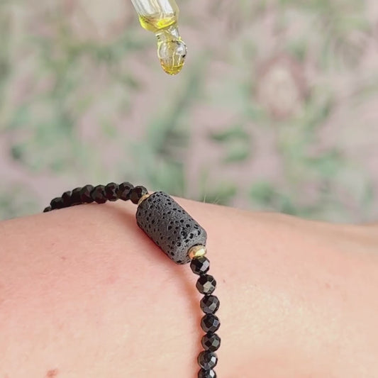 Essential oil diffuser bracelet featuring black lava rock tube bead on the band of 4mm faceted black tourmaline beads. Finished with your choice of sterling silver or gold vermeil accent beads.