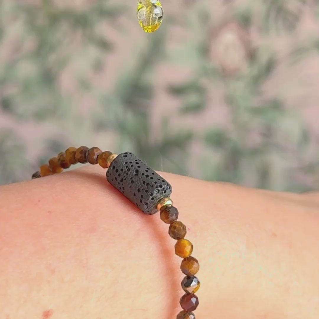 Essential oil diffuser bracelet featuring black lava rock tube bead on the band of 4mm faceted tigers eye beads. Finished with your choice of sterling silver or gold vermeil accent beads.
